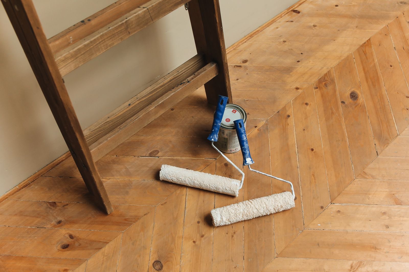Applying a fresh finish coat to a freshly sanded hardwood floor