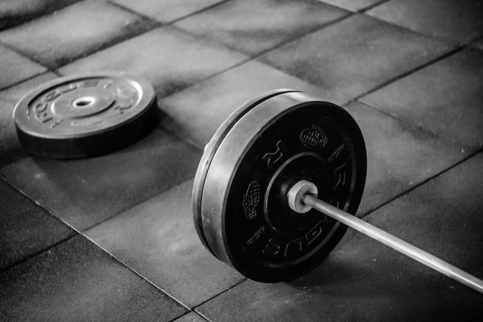 Barbell and weight plates on a rubber home-gym floor