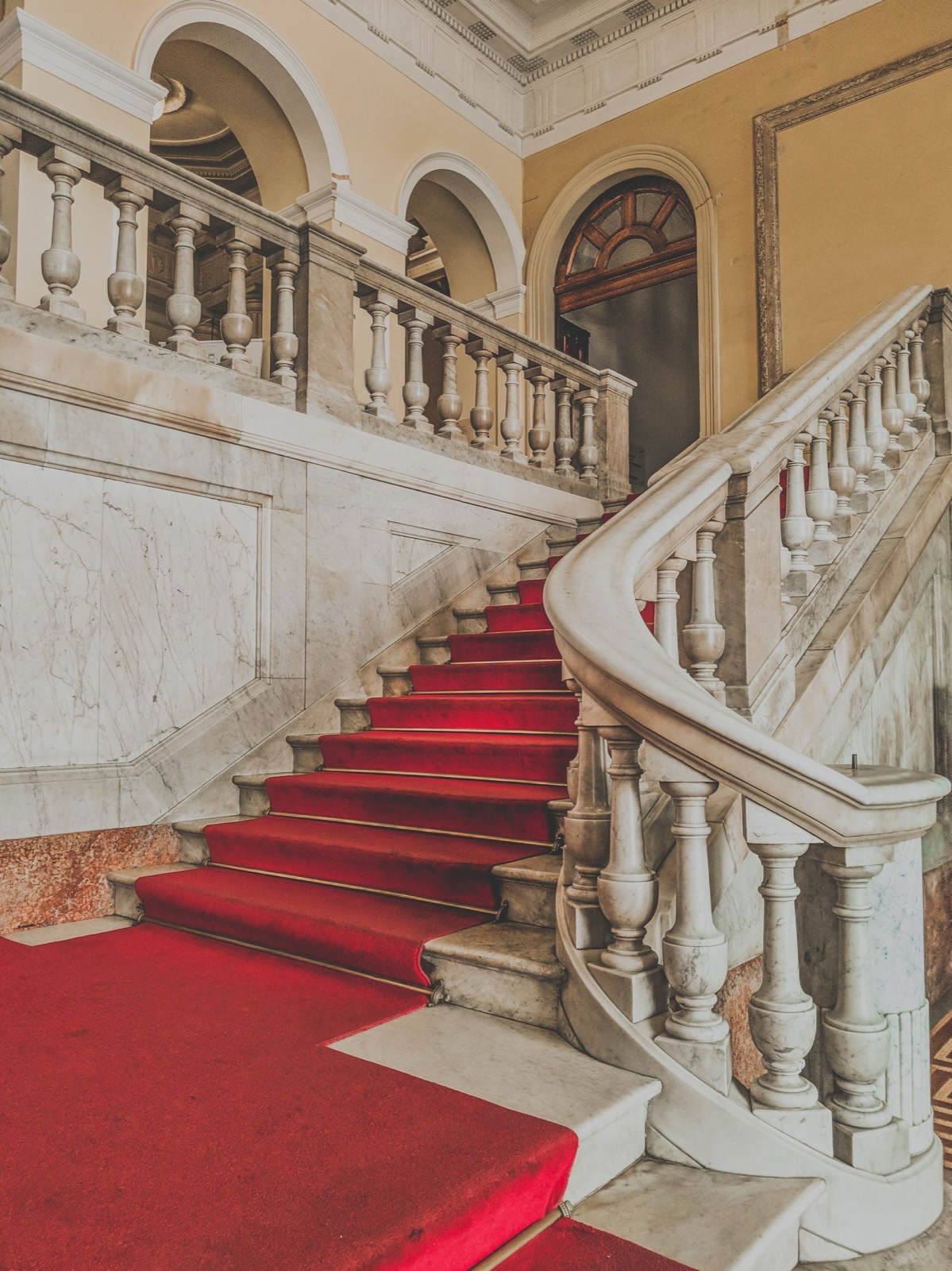 Grand curved staircase with a carpet runner